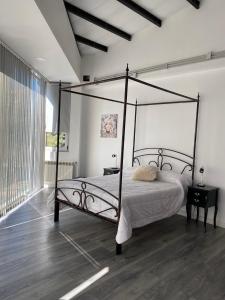 a bedroom with a canopy bed and a wooden floor at Hermoso Loft en pleno centro de Neuquen in Neuquén