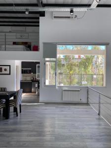 Cette grande chambre dispose d'une table et d'une grande fenêtre. dans l'établissement Hermoso Loft en pleno centro de Neuquen, à Neuquén