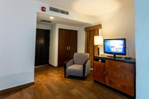 Habitación de hotel con TV y silla en HS HOTSSON Smart Value Tampico en Tampico