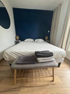 um quarto com uma cama com uma parede azul em La Kanal de Périgueux - Centre historique em Périgueux