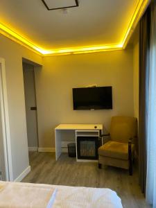Pokój z telewizorem, biurkiem i krzesłem w obiekcie Aslan Airport Hotel w mieście Arnavutköy