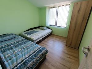 a small bedroom with two beds and a window at Витски in Ruse