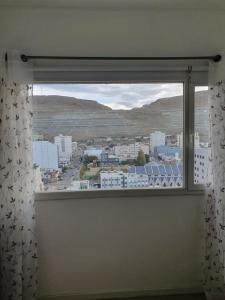 a window with a view of a city at Patagonia Alamos II in Comodoro Rivadavia