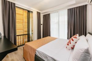 um quarto de hotel com uma cama e uma grande janela em Ella Suites Hotel em Antália