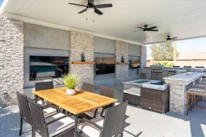 un patio con mesa, sillas y chimenea en Backyard Oasis Heated Pool Game Room Gazebo en Phoenix
