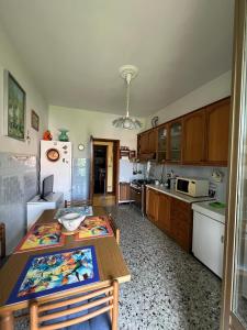 a kitchen with a table and a refrigerator at La Primula Vicinanza 5 Terre in Riccò del Golfo di Spezia