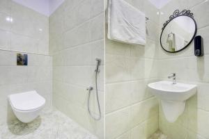 a bathroom with a toilet and a sink and a mirror at Casa Grand Hotels Nacharam in Hyderabad