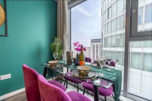 Un comedor con una mesa verde y sillas moradas. en Stylish 2 bedroom City Centre Apartment sleeps 6 with Free Convenient Bullring , Grand Central Parking, en Birmingham