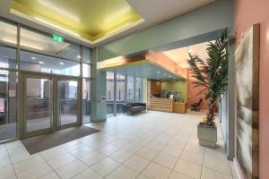 Un vestíbulo de oficina con una gran puerta de vidrio y una planta. en Stylish 2 bedroom City Centre Apartment sleeps 6 with Free Convenient Bullring , Grand Central Parking, en Birmingham