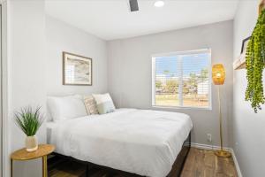 Habitación blanca con cama y ventana en Backyard Oasis Heated Pool Game Room Gazebo en Phoenix