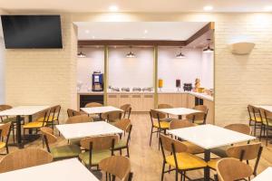 a restaurant with tables and chairs and a kitchen at Fairfield by Marriott Los Cabos in Cabo San Lucas