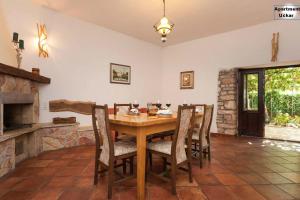 - une salle à manger avec une table et des chaises en bois dans l'établissement Apartment Uckar, à Barban