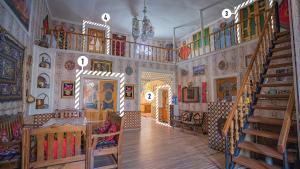 a room with a staircase and a room with paintings on the walls at Fayz in Bukhara