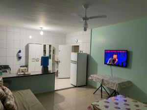 a kitchen with two refrigerators and a table and a tv at Paraíso Particular in Itanhaém