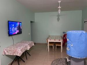 a room with two tables and a tv on the wall at Paraíso Particular in Itanhaém