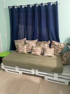 a bed with pillows on it in front of a window at Paraíso Particular in Itanhaém