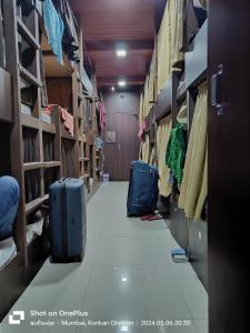 孟買的住宿－ASRA DORMITORY For Male And Female，一间房间,有两只手提箱,坐在地板上