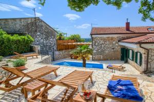 an outdoor patio with wooden furniture and a swimming pool at Villa Kirica in Bribir