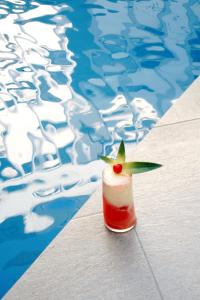 Hotel Presidente Beach Salinas في ساليناس: جلسه مشروب على طاوله بجانب مسبح
