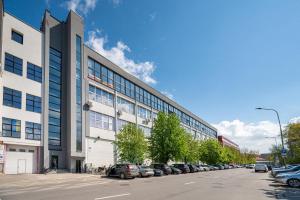 un grand bâtiment avec des voitures garées dans un parking dans l'établissement Modern & Light Loft close to City Center, à Vilnius