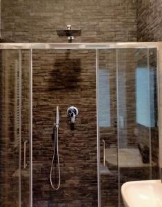 ducha con puerta de cristal y lavamanos en SERENDIPITY B&b, en Fabriano