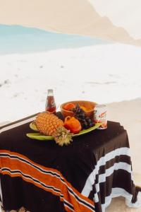 a table with a plate of fruit and a drink at Fasdheythere Inn Maldives in Kendhoo