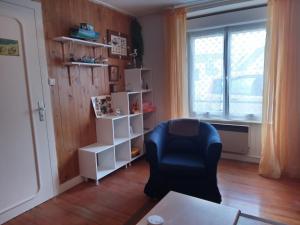 sala de estar con silla negra y ventana en MAISON AVEC JARDIN PROCHE MER, en Penmarch