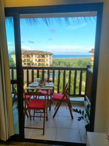 a balcony with a table and chairs and a view of the ocean at Vg Sun Cumbuco C1407 Studium in Cumbuco