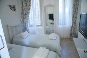 アラカティにあるApaz Alaçatı Hotelのベッド2台とテレビが備わる小さな客室です。