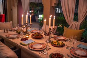 einen Tisch mit Kerzen und Teller mit Essen drauf in der Unterkunft Villa pension complète Marrakech in Marrakesch