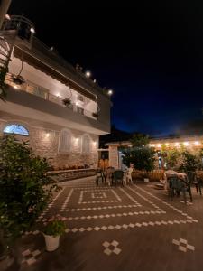 un patio con mesas y sillas por la noche en Guest House Juald en Gjirokastër