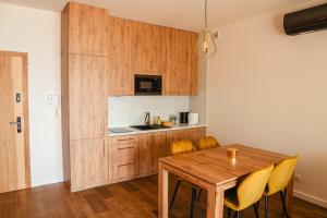 a kitchen and dining room with a wooden table and chairs at Boszkowo Horizon Park in Boszkowo-Letnisko