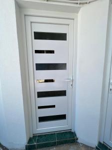 a white garage door in a white wall at GRAMISI apartments in Kruče