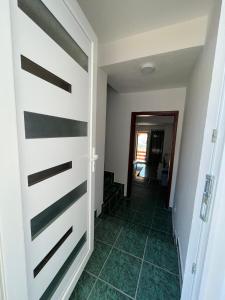 a door leading to a hallway with green tiles at GRAMISI apartments in Kruče