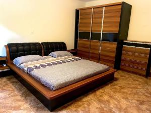 1 dormitorio con 1 cama y armario de madera en Mapunda House, en Lubango
