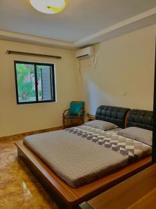 1 dormitorio con 2 camas y ventana en Mapunda House, en Lubango