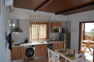 cocina con mesa, fregadero y nevera en Galeón Ossorio Vistas Panoramicas, en Vallehermoso