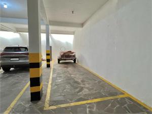 uma garagem com um carro estacionado nela em Quarto em Apartamento Amplo e Confortável em Caxias do Sul