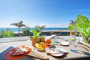 a table with food and a view of the ocean at Amapola Palms - recién reformado, frente al mar in San Agustin