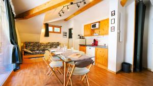 een keuken met een tafel en stoelen in een kamer bij Chalet De Florence - 3 Pièces pour 8 Personnes 124 in Modane