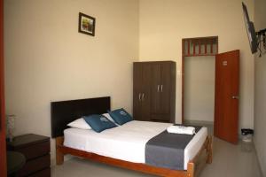 1 dormitorio con 1 cama con almohadas azules y blancas en Estancia Real en Piura