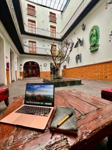 einen Laptop auf einem Holztisch mit einem Stift darauf in der Unterkunft Hotel Puebla Plaza in Puebla