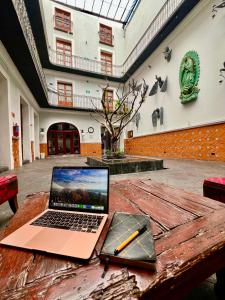 a laptop on a wooden table with a pencil on it at Hotel Puebla Plaza in Puebla