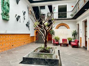 un patio con un árbol en el medio de un edificio en Hotel Puebla Plaza, en Puebla