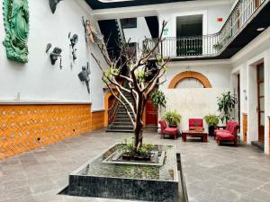 a courtyard with a tree in the middle of a building at Hotel Puebla Plaza in Puebla