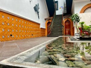 a building with a pool of water in front of a house at Hotel Puebla Plaza in Puebla