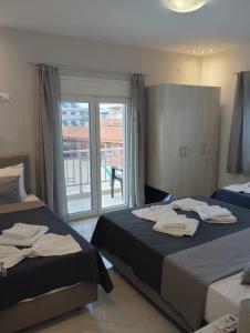 a hotel room with two beds and a window at Gold Sand Apartments in Paralia Katerinis