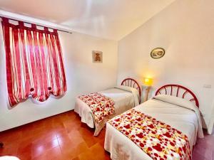 two beds in a room with red curtains at AGRITURISMO LA MOROLLA in Marsciano +35 photos