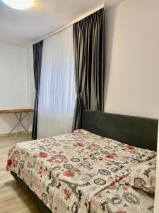 een slaapkamer met een bed met een deken erop bij Mainstreet Apartments Suceava in Suceava