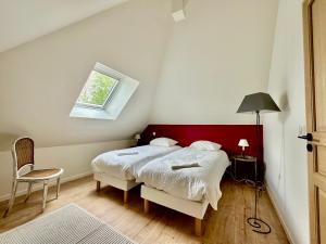 a bedroom with a bed and a chair and a window at une maison d'hôtes alliant charme et confort in Saint-Pierre-du-Val